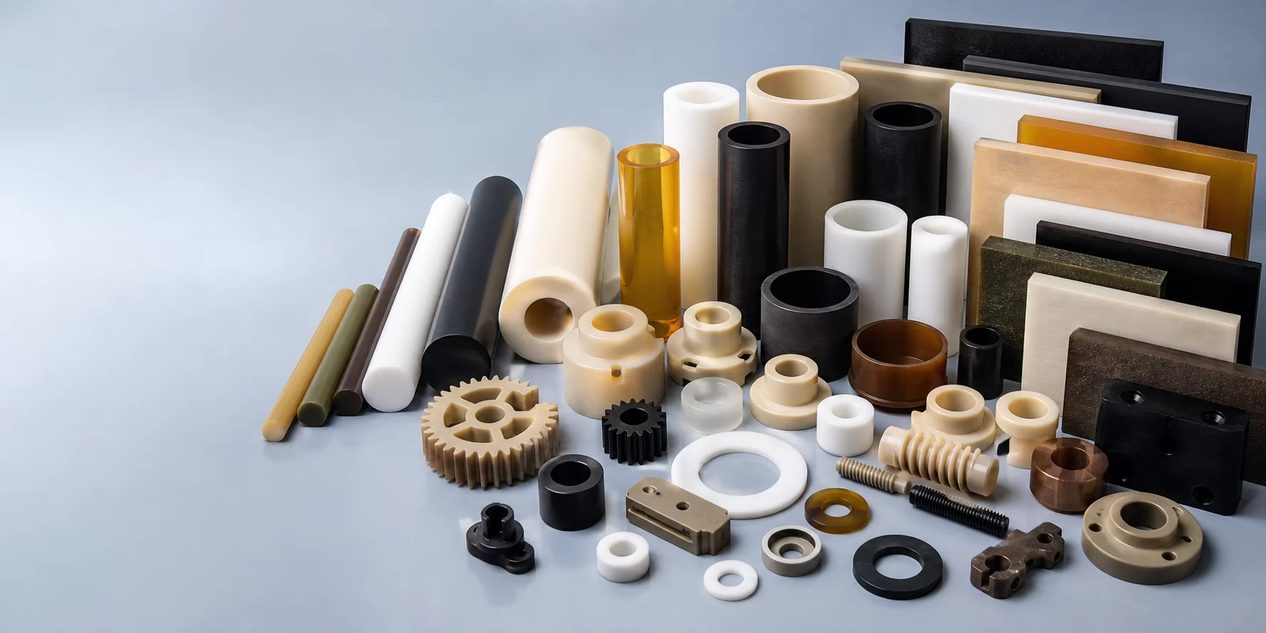 High performance engineering plastic rods plates tubes and machined components arranged on a clean blue gray studio surface